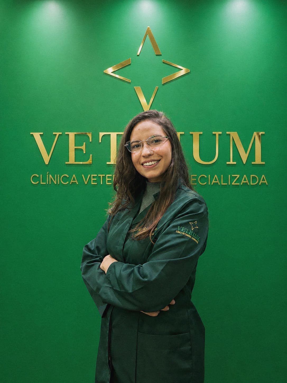 Nicole Pascarelli, médica-veterinária da Vetrium, sorrindo em frente ao logo da clínica